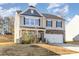 Two story house with stone and beige vinyl siding, two car garage, and landscaping at 6514 Ellimar Field Ln, Charlotte, NC 28215