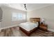 Bedroom with a wooden platform bed, nightstand, and plantation shutters at 16100 Woolwine Rd, Charlotte, NC 28278