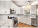 Updated kitchen with white shaker cabinets, stainless steel appliances, and gray tile backsplash at 6500 Forestrock Dr, Charlotte, NC 28269