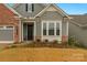 Gray siding with brick accents and a black front door at 7014 Jolly Brook Dr, Charlotte, NC 28215