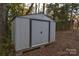 Metal storage shed in a wooded backyard setting at 705 Michigan St, Kannapolis, NC 28083