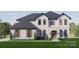 Two-story home with white brick, dark gray roof, and landscaping at 0 S Potter Rd # 1A, Waxhaw, NC 28173