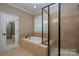 Bathroom with soaking tub and glass shower at 10528 Royal Winchester Dr, Charlotte, NC 28277