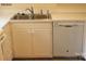 Galley kitchen with white cabinets, stainless steel sink, and dishwasher at 4605 Coronado Dr, Charlotte, NC 28212