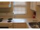White kitchen with an electric stove, cabinets and a window at 4605 Coronado Dr, Charlotte, NC 28212