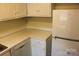 Corner kitchen with white cabinets, countertops, and appliances at 4605 Coronado Dr, Charlotte, NC 28212