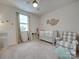Bedroom featuring a crib, armchair, and window at 5021 Markfield Ln, Monroe, NC 28110