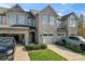 Stone exterior townhome with 2-car garage and landscaped lawn at 7333 Dulnian Way, Charlotte, NC 28278