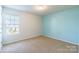 Charming bedroom with light blue accent wall and neutral carpet at 8127 Paw Club Dr, Charlotte, NC 28214