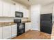 Bright kitchen featuring white cabinets, granite countertops, and black appliances at 8127 Paw Club Dr, Charlotte, NC 28214