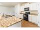 Clean kitchen with granite countertops, white cabinets, and a breakfast bar at 8127 Paw Club Dr, Charlotte, NC 28214