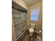 Updated bathroom with a walk-in shower, toilet and vinyl flooring at 7154 Woodcock Trl, Stanley, NC 28164