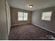 Spacious bedroom with neutral walls, carpet flooring, and large windows at 7154 Woodcock Trl, Stanley, NC 28164