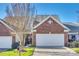 Brick front exterior of charming townhome with two-car garage and landscaping at 312 Garnet Ct, Fort Mill, SC 29708