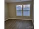 Well-lit bedroom with two windows and grey flooring at 1174 Plaza Walk Dr, Charlotte, NC 28215