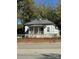 Small white house with front porch and brick wall at 1202 Main W St, Rock Hill, SC 29732