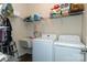 Bright laundry room with washer, dryer, and ample shelving at 14425 Beatties Ford Rd, Huntersville, NC 28078