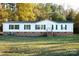 White single-wide mobile home with brick skirting, green shutters, and a spacious yard at 3678 Old Camden Hwy, Heath Springs, SC 29058