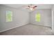 Well-lit bedroom with ceiling fan and two windows at 7208 Stoney Wood Ln, Charlotte, NC 28215