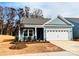 Newly built home with gray siding, white garage door, and landscaping at 1058 Bull Dog Ln, Wingate, NC 28174