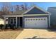 One-story home with gray siding, white garage door, and landscaping at 1058 Bull Dog Ln, Wingate, NC 28174