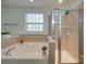 Bathroom with tub and shower, tile flooring and window at 11628 Eastwind Dr, Charlotte, NC 28273