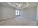 Spacious main bedroom with carpet, ceiling fan, and large windows at 11628 Eastwind Dr, Charlotte, NC 28273