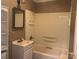 Bathroom with white tub, sink, and beige walls at 707 7Th St, Spencer, NC 28159