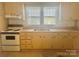 Small kitchen with light cabinets, electric stove, and double sink at 707 7Th St, Spencer, NC 28159