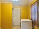 Laundry room with yellow walls, white door, and washer at 707 7Th St, Spencer, NC 28159