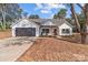 White farmhouse exterior with dark garage door and landscaping at 1238 Miller Chapel Rd, Salisbury, NC 28147