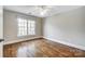 Empty bedroom with hardwood floors, white trim, and large window at 12539 Overlook Mountain Dr, Charlotte, NC 28216