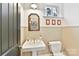 Charming bathroom with pedestal sink, wainscoting, and a window at 208 Grey Rd, Davidson, NC 28036