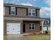 Townhome with brick and siding, two-car garage, and a neatly landscaped yard at 5156 Tommy Ln # 1301, Stanley, NC 28164
