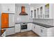 Modern kitchen with white cabinets, orange refrigerator, and copper range hood at 1406 Lonan Dr, Waxhaw, NC 28173