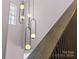 Modern light fixture with circular accents hanging on the staircase at 1406 Lonan Dr, Waxhaw, NC 28173