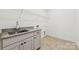 Bright laundry room with granite countertop, stainless steel sink, and ample shelving at 148 Windy Dell Dr, Tega Cay, SC 29708