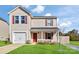 Two-story house with beige vinyl siding, red accents, and a two-car garage at 213 Morton St, Shelby, NC 28152