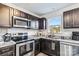 Modern kitchen with dark brown cabinets, granite countertops, and stainless steel appliances at 213 Morton St, Shelby, NC 28152