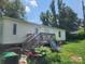 Rear view of mobile home with wooden deck and small yard at 249 Shady Grove Rd # 21, Kings Mountain, NC 28086