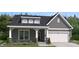 Gray two-story house with white accents and a two-car garage at 3233 Whispering Creek Dr # 091, Indian Trail, NC 28079