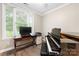 Home office featuring a piano, desk, and large window with blinds at 416 Queens Rd # 11, Charlotte, NC 28207