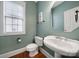 Small powder room with a pedestal sink and wood flooring at 8908 Red Barone Pl, Waxhaw, NC 28173