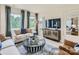 Living room featuring a beige sofa, brown accent chairs, and a large TV at 1808 Otter Perch Ln, Fort Mill, SC 29715