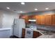 Galley kitchen with wood cabinets, white appliances, and corner sink at 229 Arlington Downs Blvd, Matthews, NC 28104