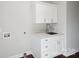 Laundry room with utility sink and built-in shelving at 104 Vista Dr, Davidson, NC 28036