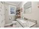 Bathroom with granite countertop vanity, floral shower curtain, and a three-tiered shelf at 1065 14Th Nw Ave, Hickory, NC 28601