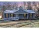 Blue Ranch home with lights on the porch at dusk at 11236 Mallard Crossing Dr, Charlotte, NC 28262