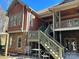 Two-story home with stone and red siding, deck, and stairs leading to the backyard at 1327 Moonshadow Ln, Shelby, NC 28150