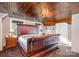 Spacious bedroom with a leather sleigh bed and wood ceiling at 228 Sugar Loaf Dr, Troy, NC 27371